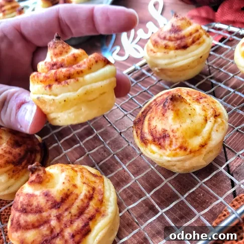 Loaded Mashed Potato Bombs: Crispy Potato Bites with Cheesy Center 5 A finished potato puff being held up above other puffs