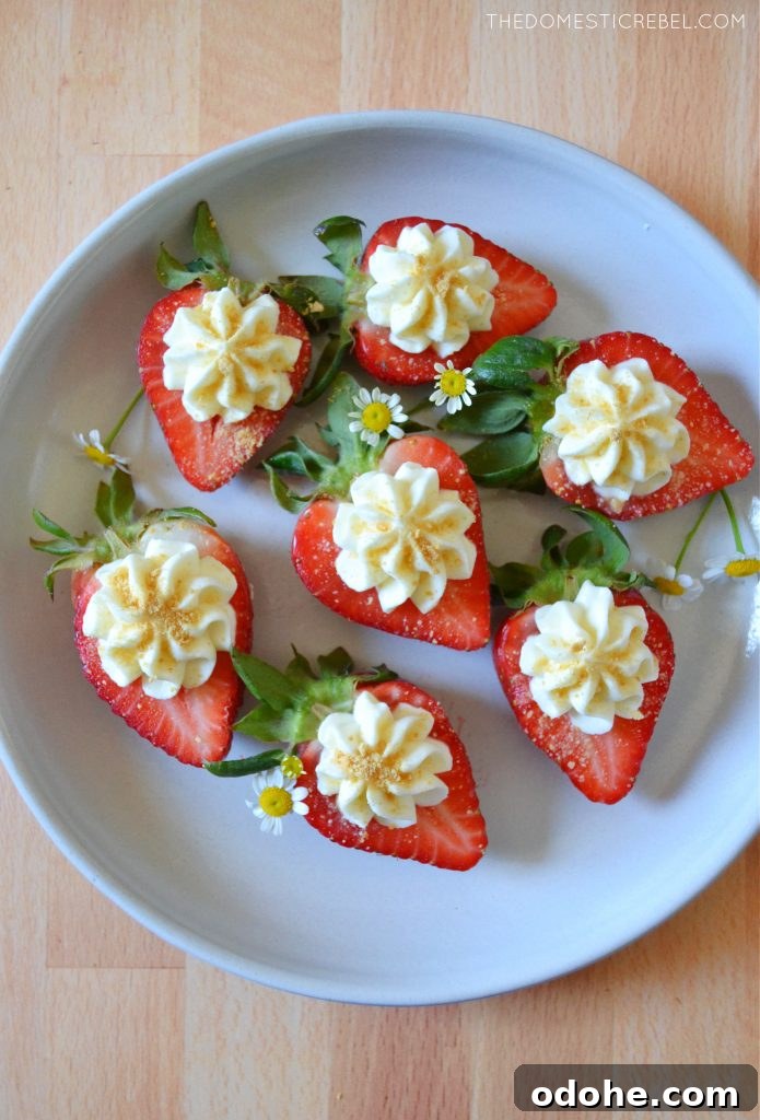 white plate with cheesecake deviled strawberries and little daisies on it