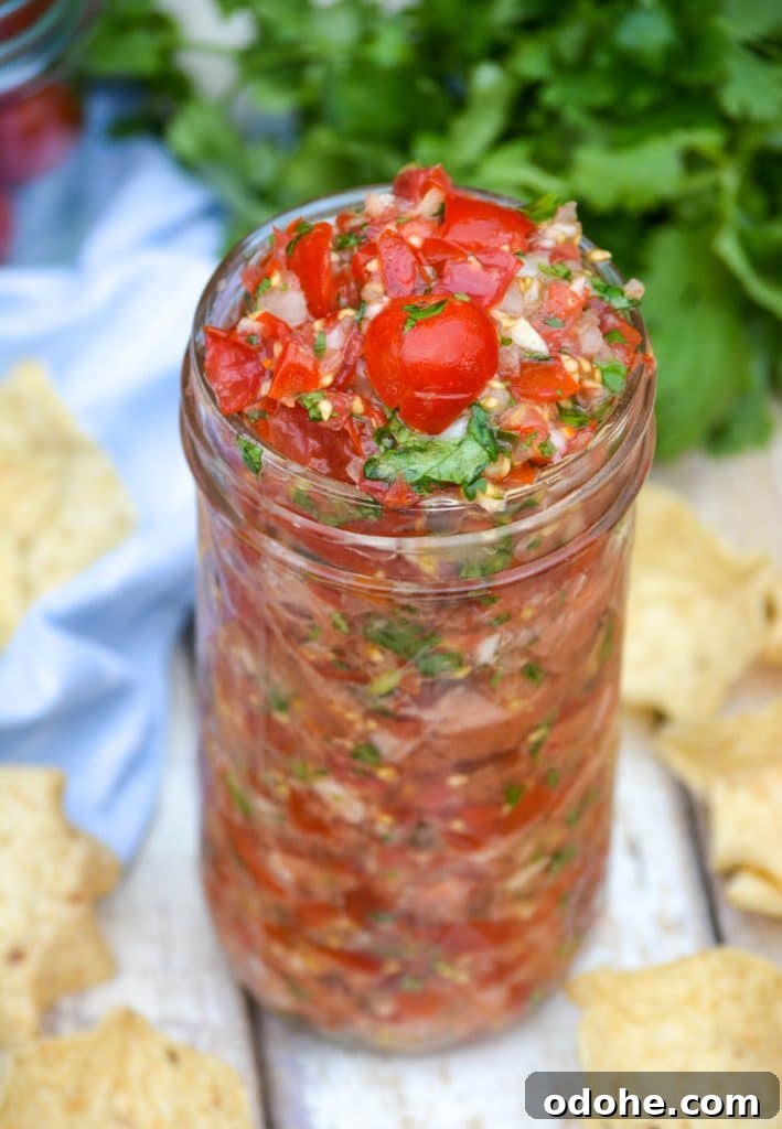 a glass jar filled with fresh tomato salsa
