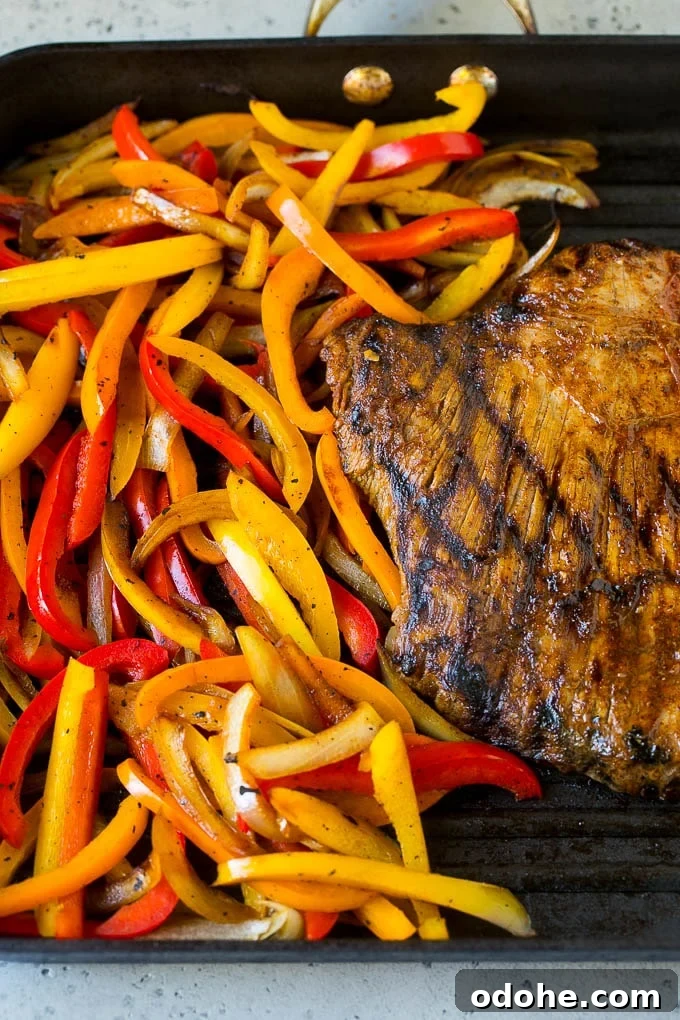 Steak Fajitas Recipe | Beef Fajitas | Steak Recipe #fajitas #steak #beef #mexicanfood #dinner #dinneratthezoo Flank steak and sliced peppers on a grill pan.