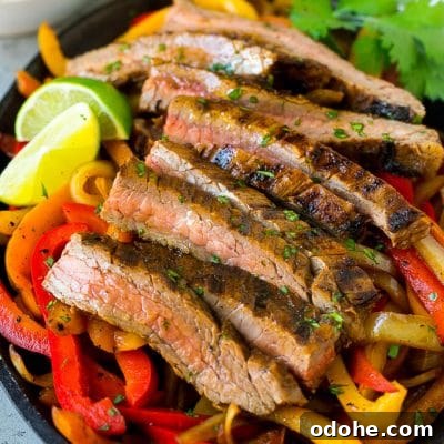 Sizzling Steak Fajitas with Peppers and Onions Recipe 2 Steak fajitas served on a bed of seared peppers and onions.