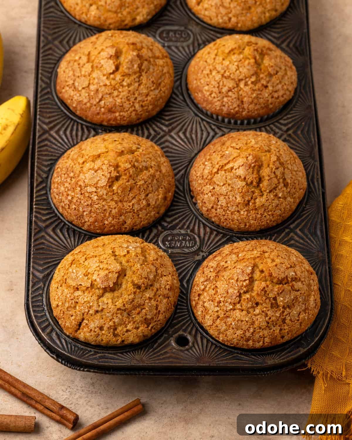 A muffin tin with freshly baked pumpkin banana muffins.