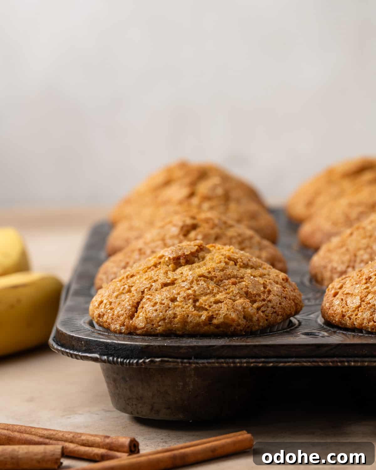 Freshly baked pumpkin banana muffins in a metal muffin tin.