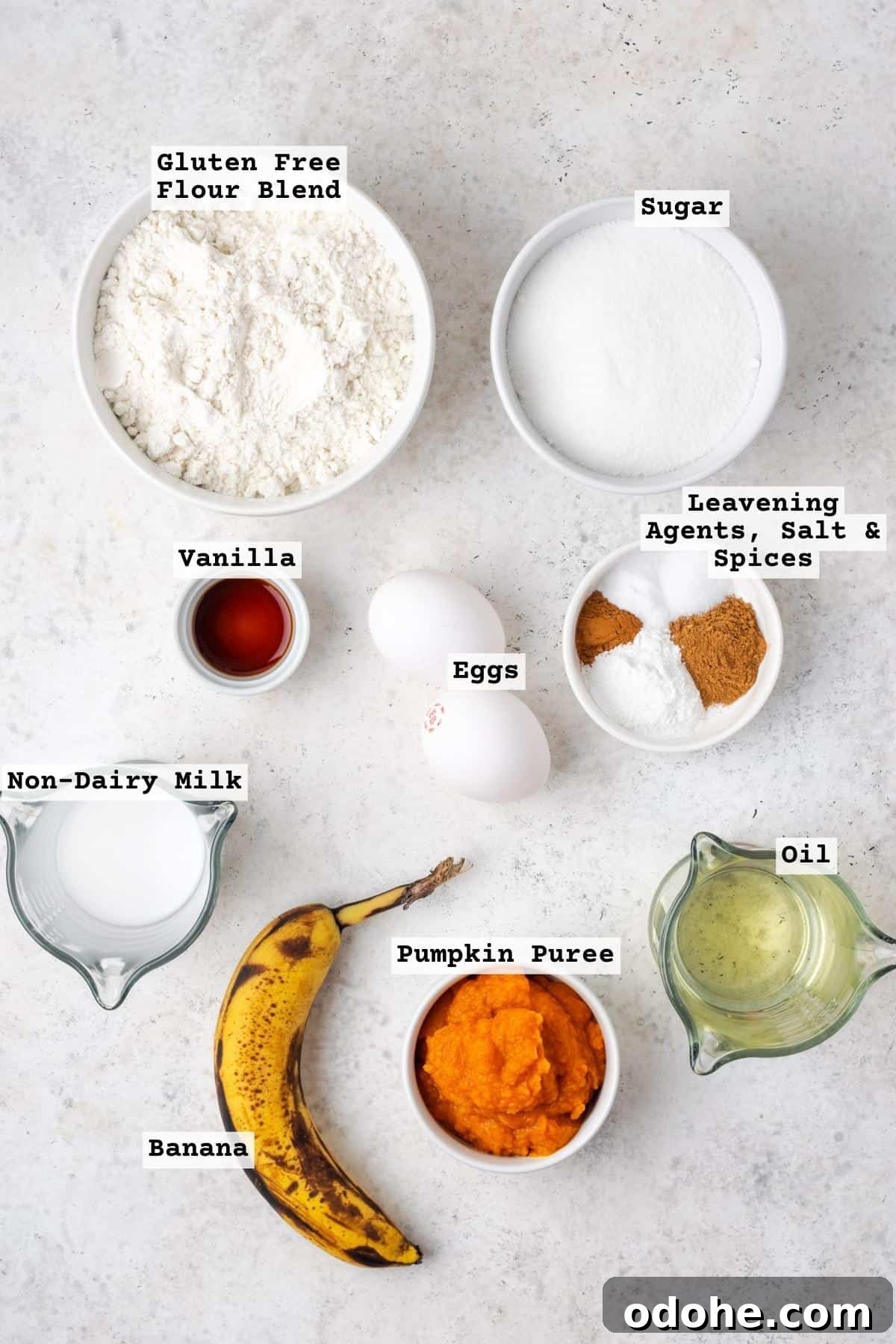 Ingredients for pumpkin banana muffins on a white table.
