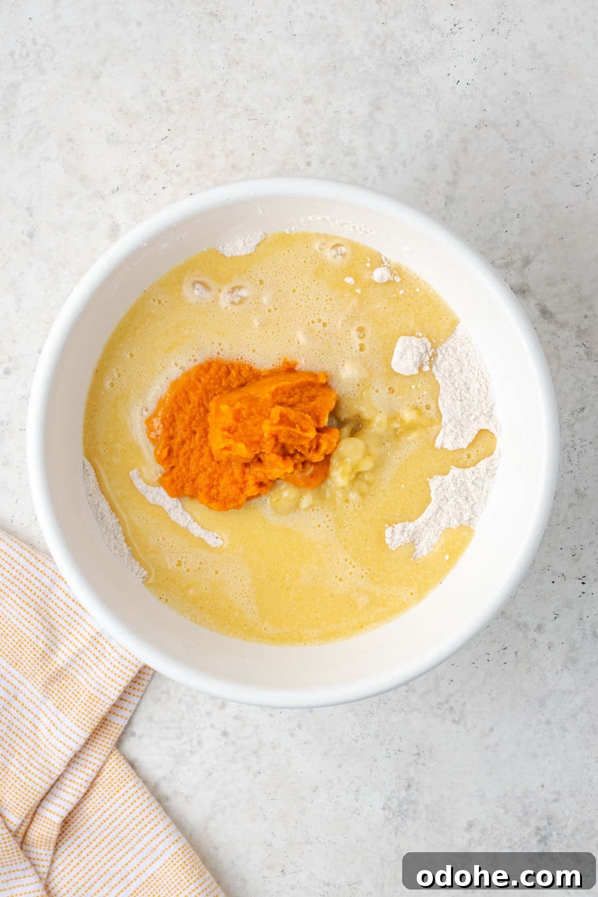 Wet ingredients, mashed banana and pumpkin puree all added to the dry ingredients in a large mixing bowl.