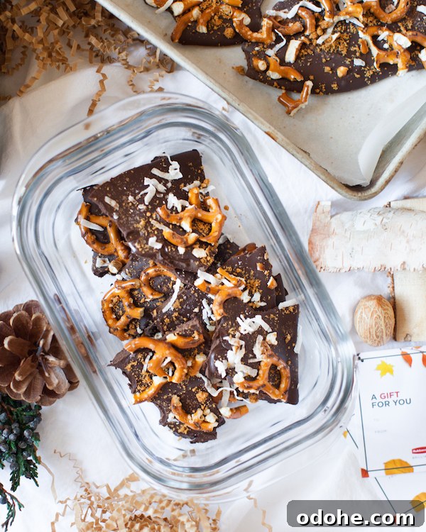 Glass storage container filled with uneven pieces of Biscoff Crumble Chocolate Bark.