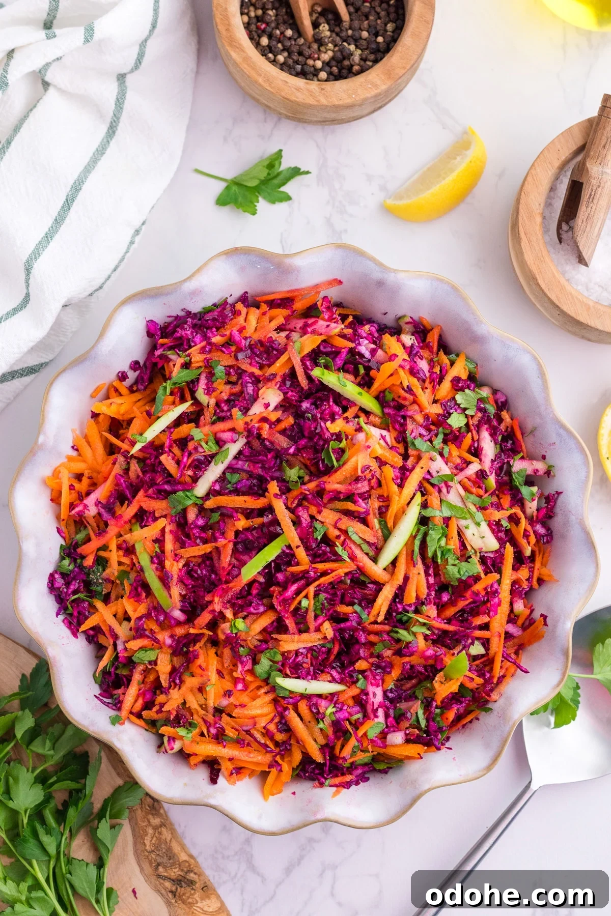 Crunchy Cabbage and Carrot Salad with Zesty Dressing 2 A bowl filled with shredded red cabbage, carrot, and green apple.