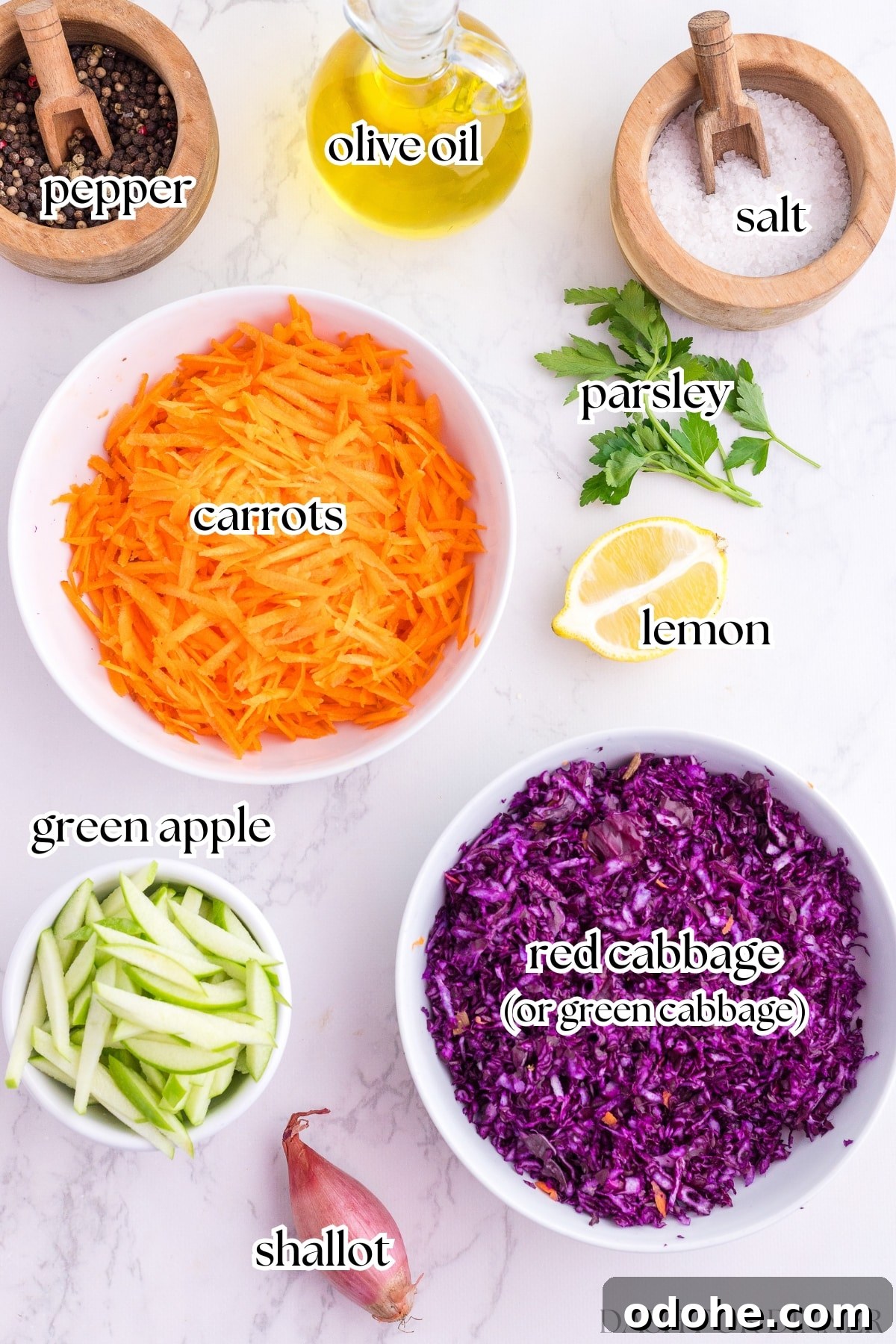 Crunchy Cabbage and Carrot Salad with Zesty Dressing 3 The ingredients needed to make cabbage and carrot salad, including shredded vegetables, apple, parsley, lemon, and olive oil.