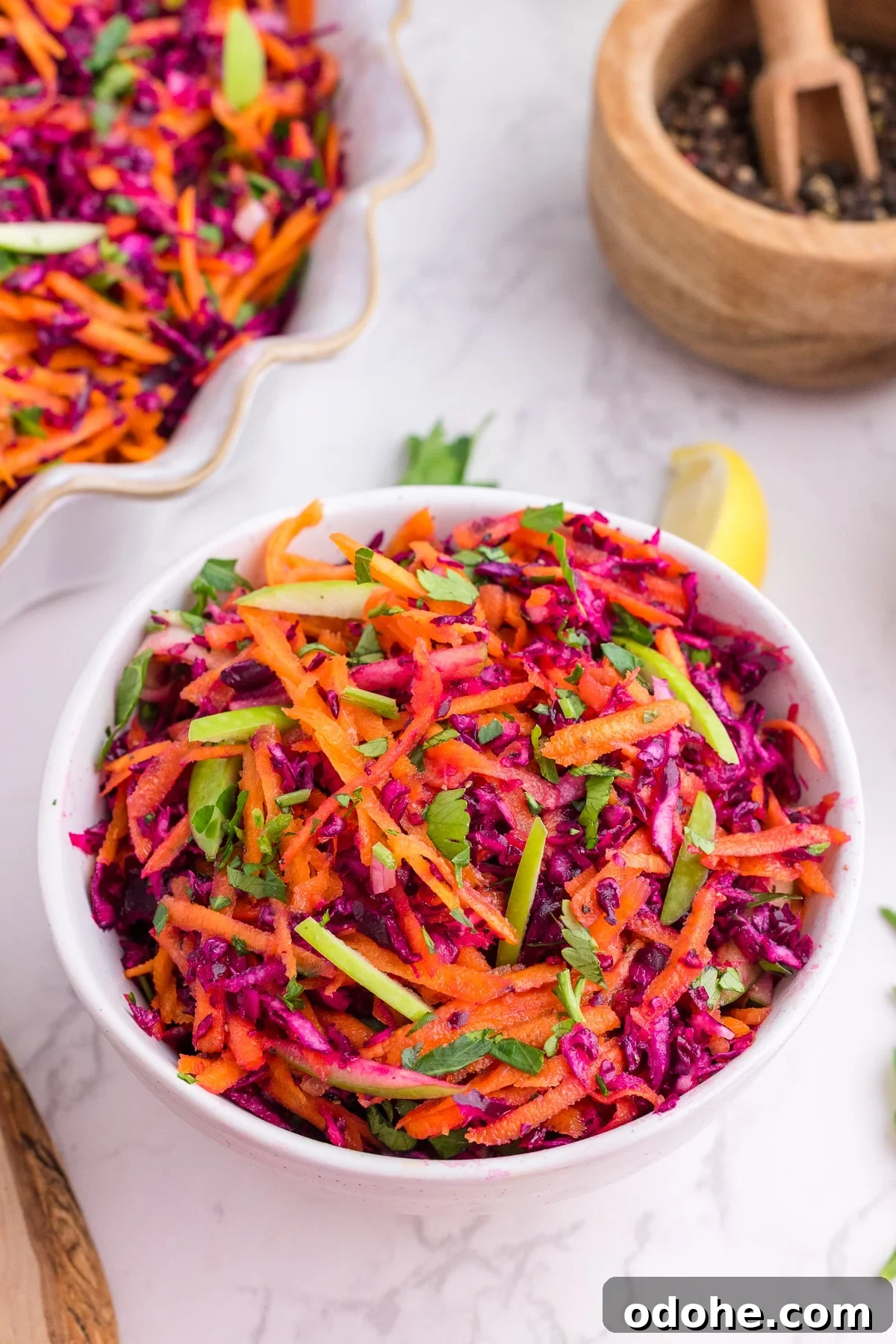 Crunchy Cabbage and Carrot Salad with Zesty Dressing 7 A bowl of cabbage and carrot slaw, garnished with fresh parsley.