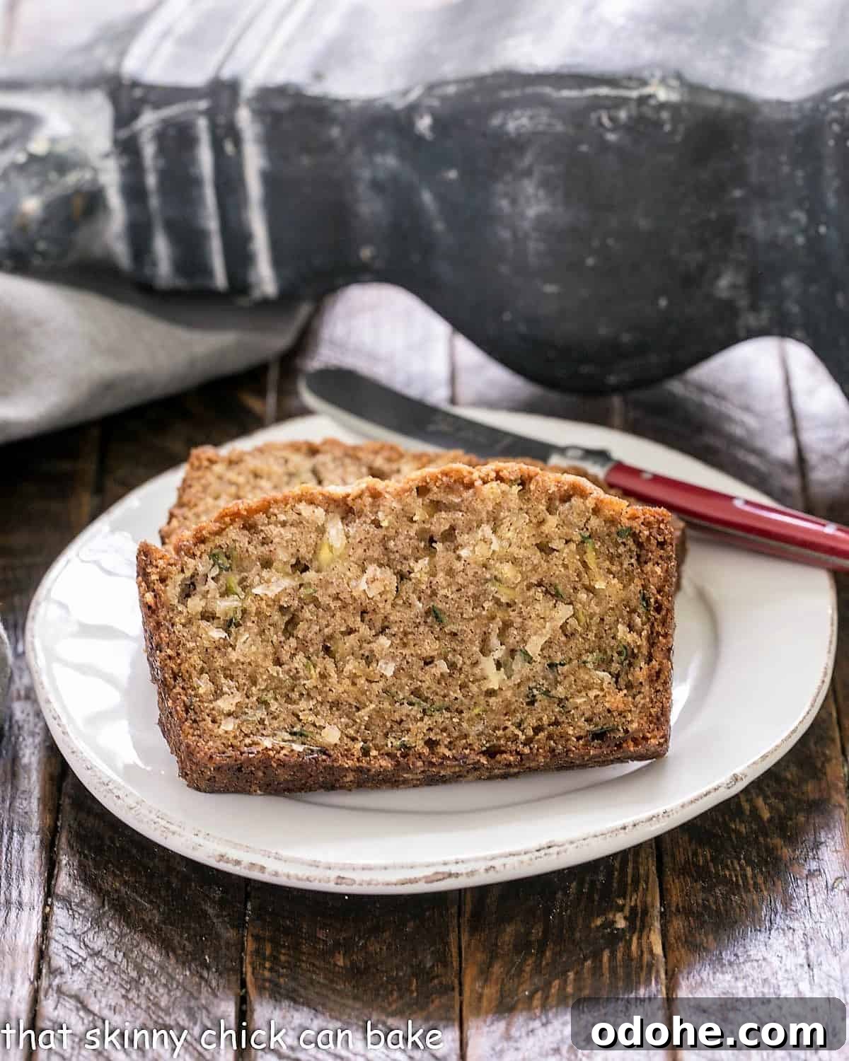Pineapple Coconut Zucchini Quick Bread with Tropical Flavor 3 Slices of zucchini bread recipe on a white plate with a red handled knife.