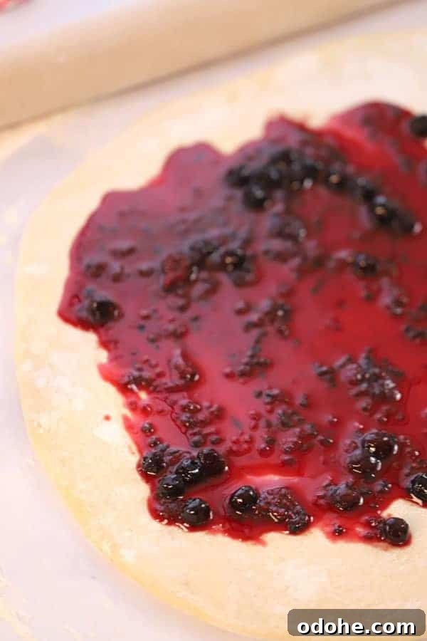 Sweet roll dough rolled out into a rectangle and covered with berry compote.