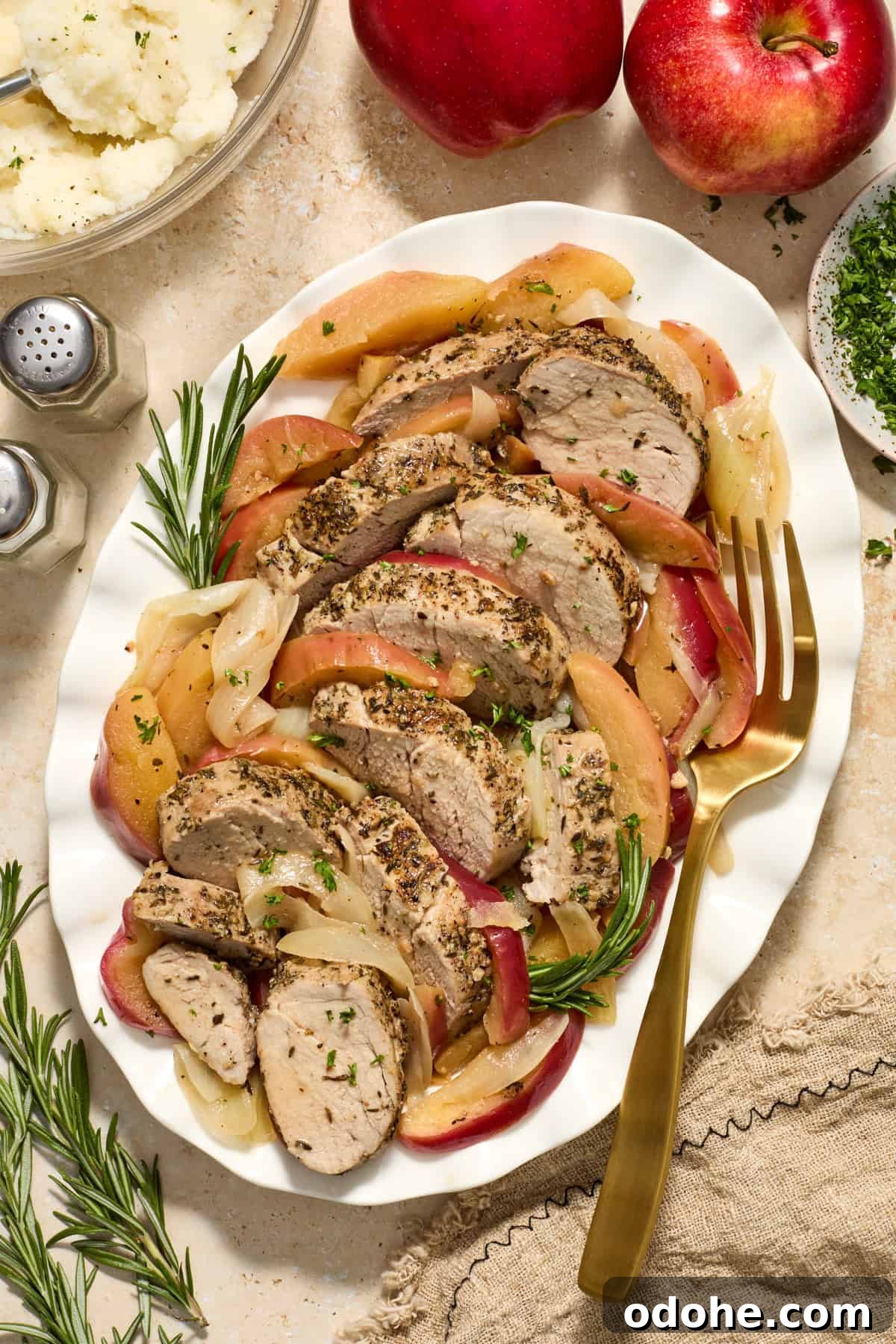 Perfect Instant Pot Pork Tenderloin Recipe for Juicy Results 12 Serving platter with pork tenderloin slices, apples and rosemary.