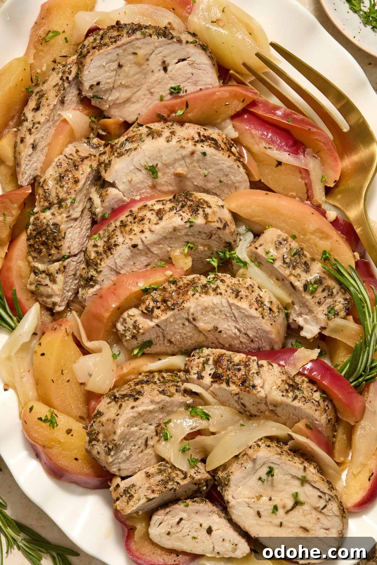 Perfect Instant Pot Pork Tenderloin Recipe for Juicy Results 13 Sliced pork on serving platter with cooked apples and onions.