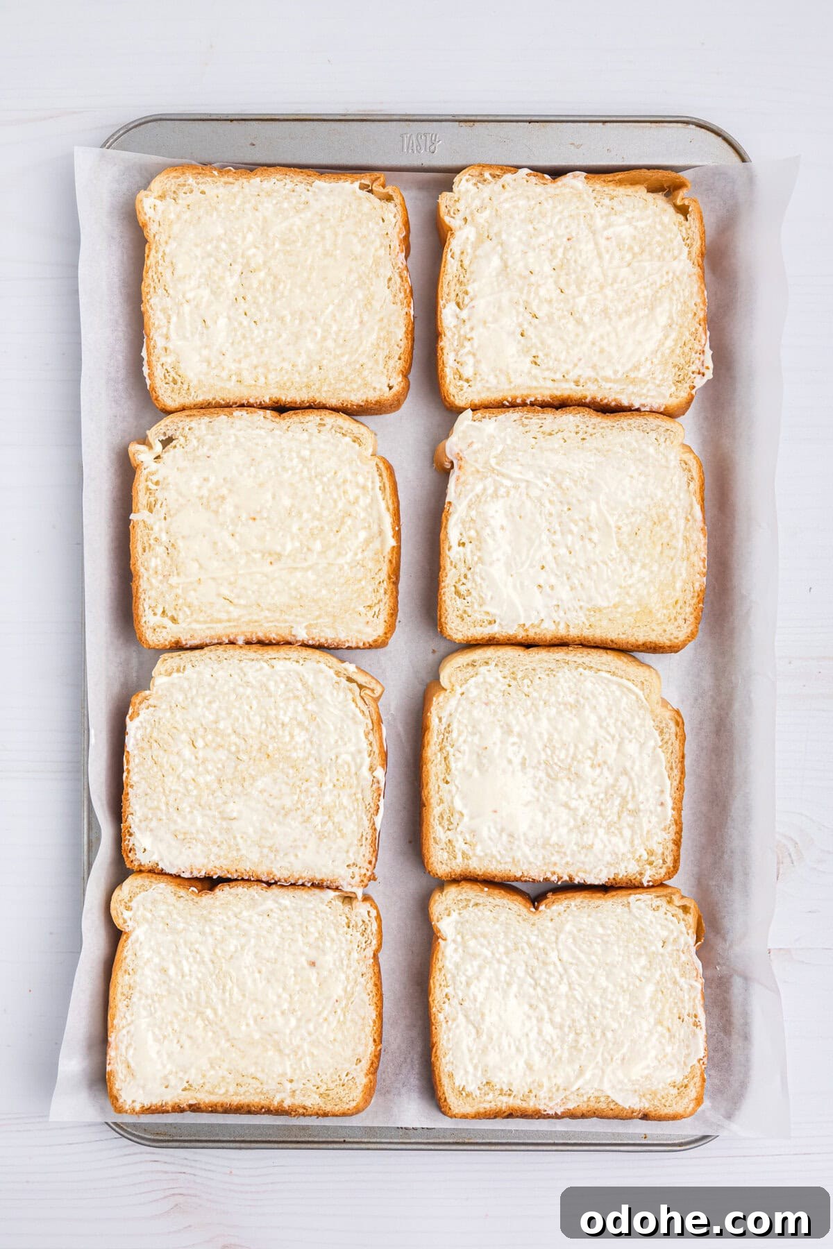 Perfect Grilled Cheese on a Blackstone Griddle: Melted & Crispy 4 Tray lined with bread pieces smeared with mayonaise for Blackstone Grilled Cheese recipe