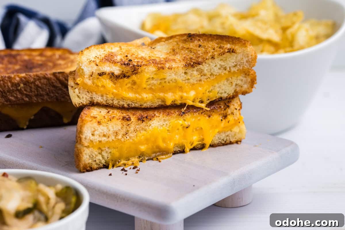 Perfect Grilled Cheese on a Blackstone Griddle: Melted & Crispy 10 Blackstone Grilled Cheese cut in half and stacked on serving plate