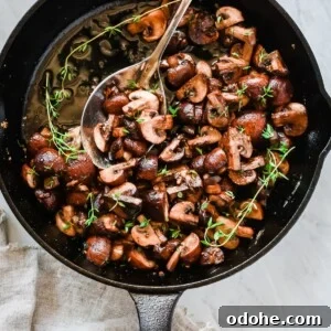 Garlic Butter Mushrooms Skillet Recipe for Weeknight Dinner 4 Overhead photo of a cast iron pan with garlic butter mushrooms inside.