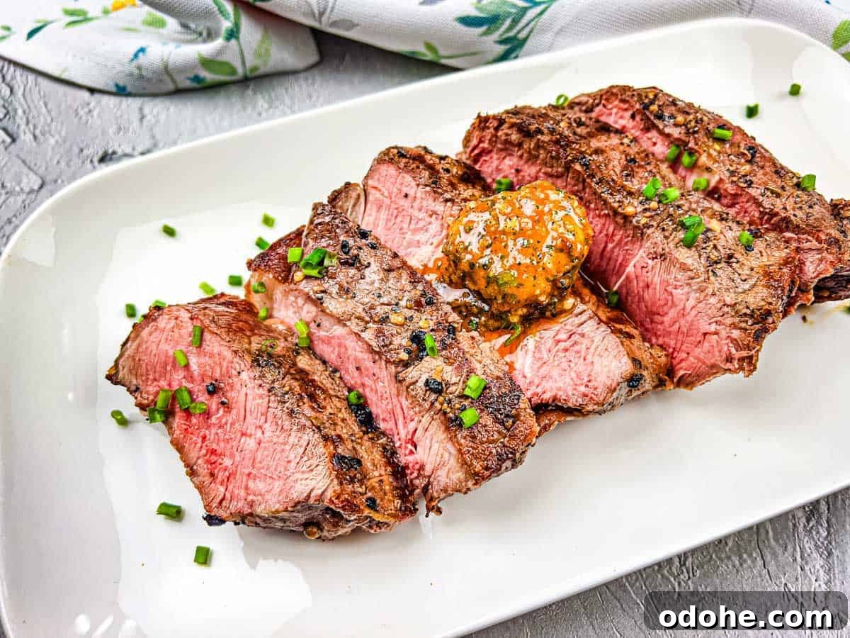 31 Memorial Day Recipes to Start Cookout Season Right 24 A grilled steak with cowboy butter on a white plate.