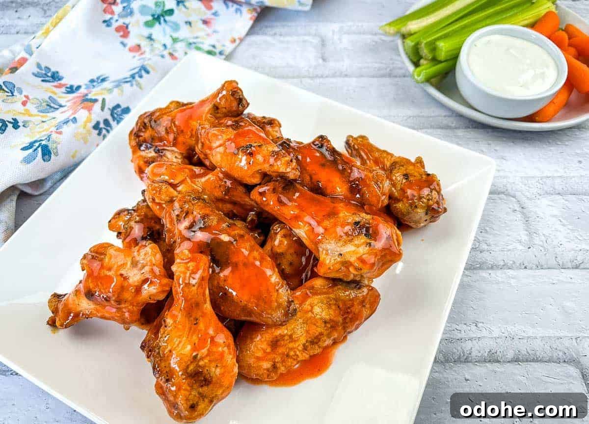 31 Memorial Day Recipes to Start Cookout Season Right 28 Grilled Chicken Wings with Buffalo Sauce on a white square plate.