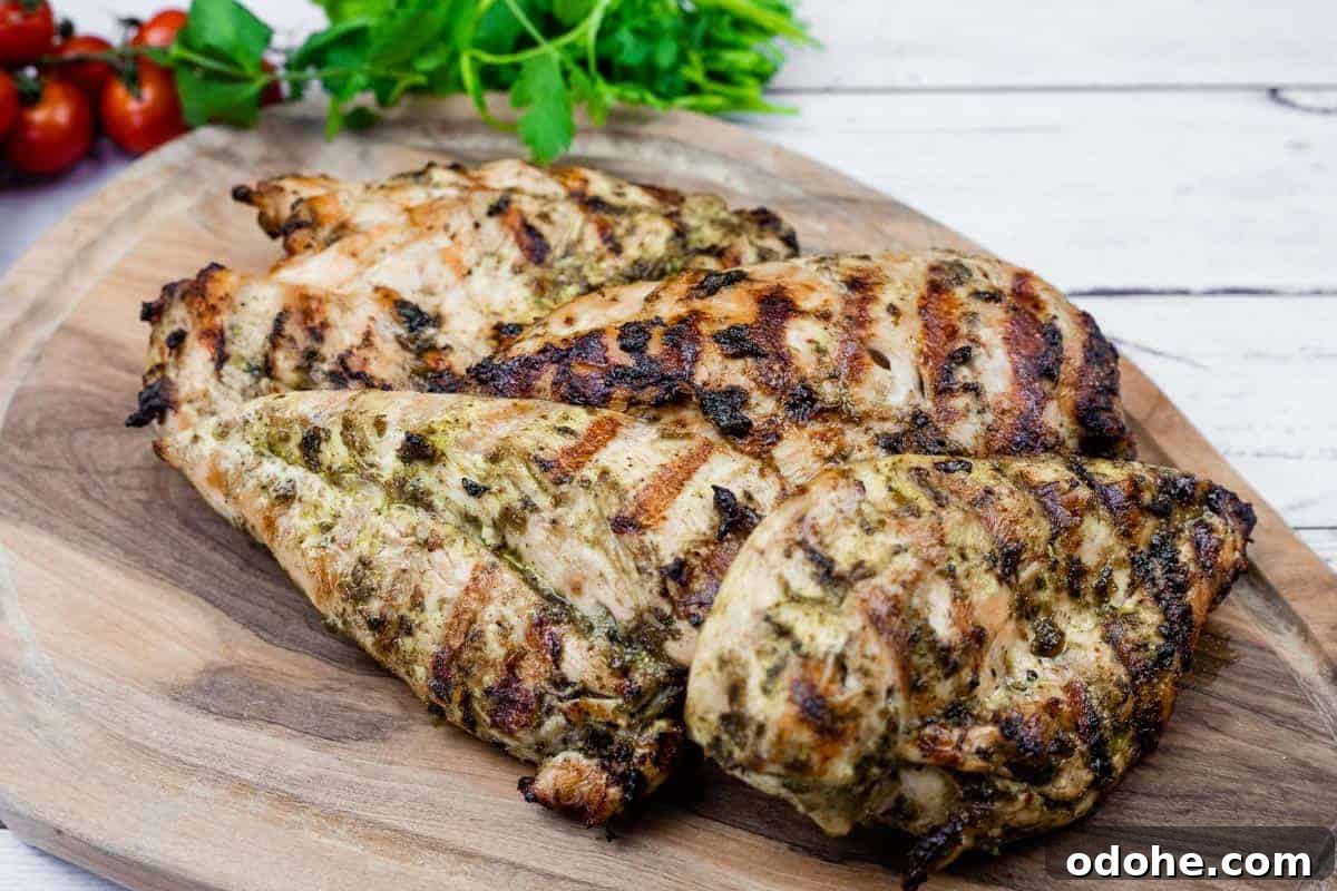 31 Memorial Day Recipes to Start Cookout Season Right 32 Grilled chicken on a wooden board with cilantro and tomatoes in the back.