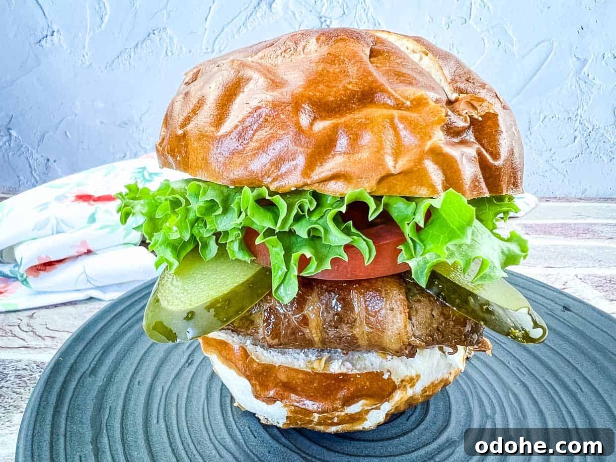 31 Memorial Day Recipes to Start Cookout Season Right 10 Bacon-Wrapped Burger on a black plate.