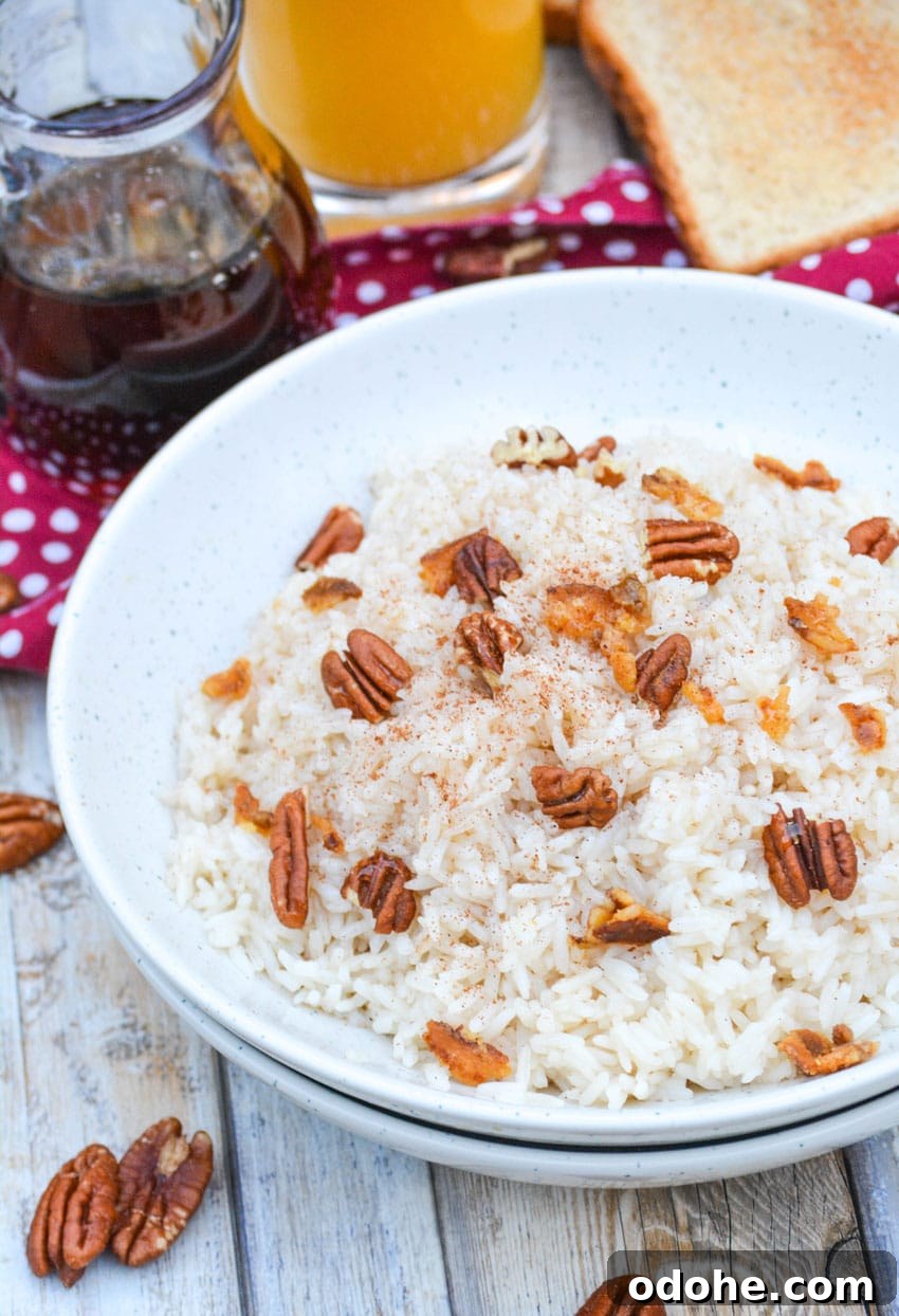 breakfast rice in a white bowl topped with pecans and crumbled bacon