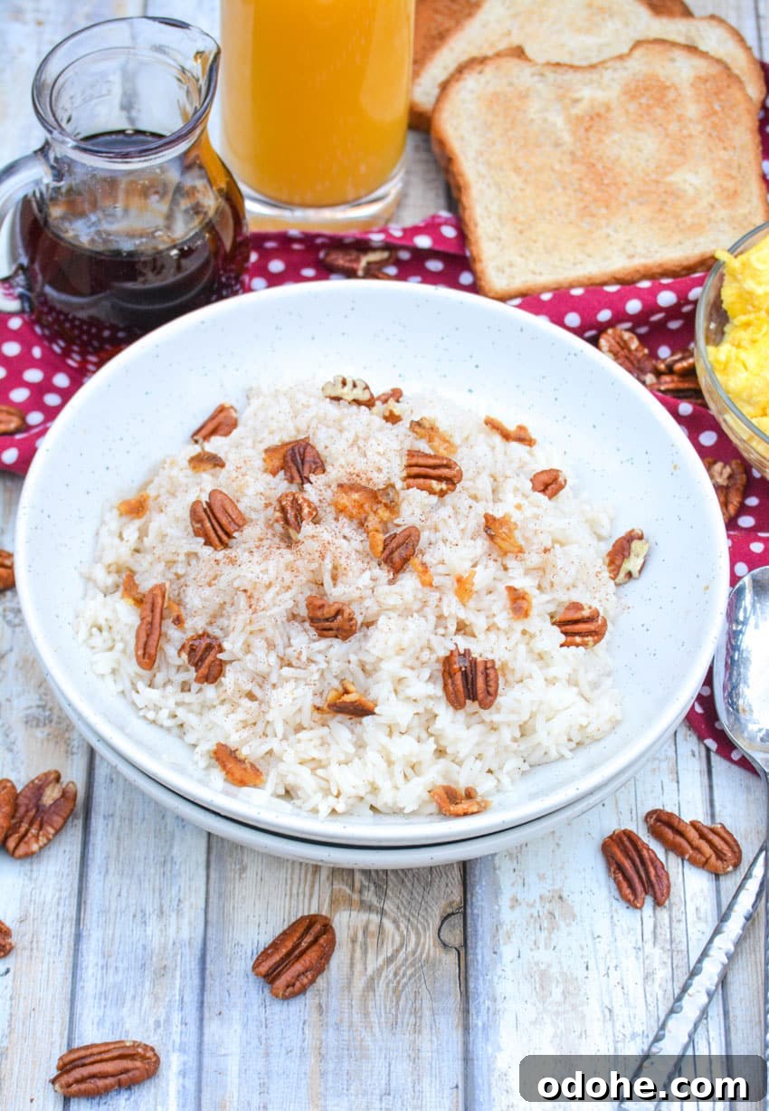 breakfast rice in a white bowl topped with pecans and crumbled bacon