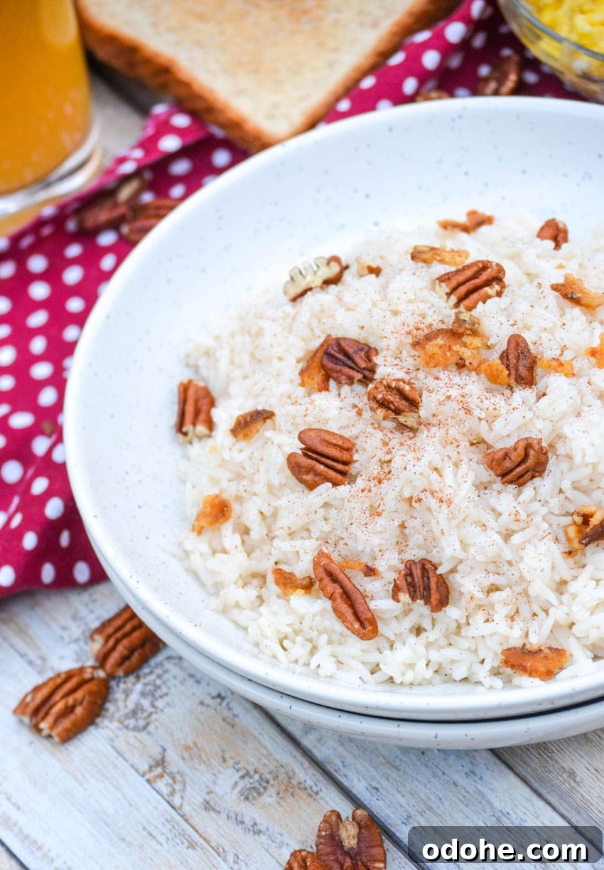 breakfast rice in a white bowl topped with pecans and crumbled bacon