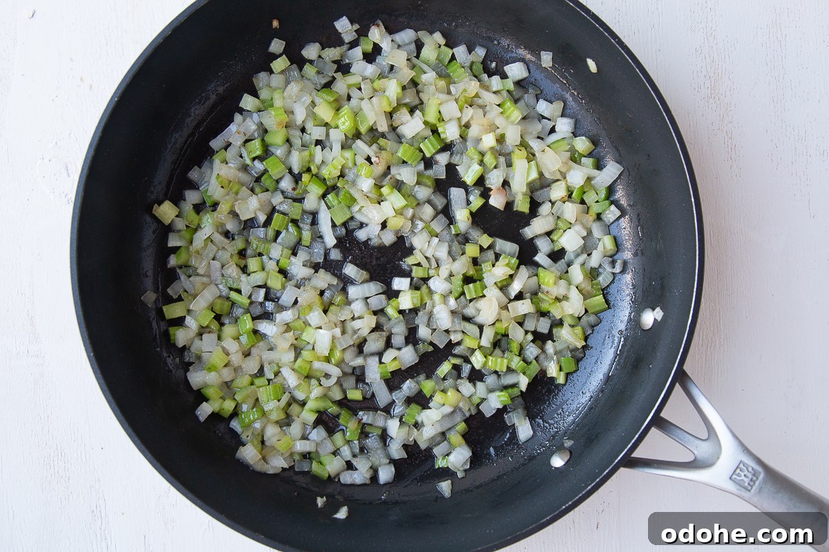 Authentic German Potato Salad with Hard-Boiled Eggs & Bacon 8 onion and celery cooking in a nonstick pan