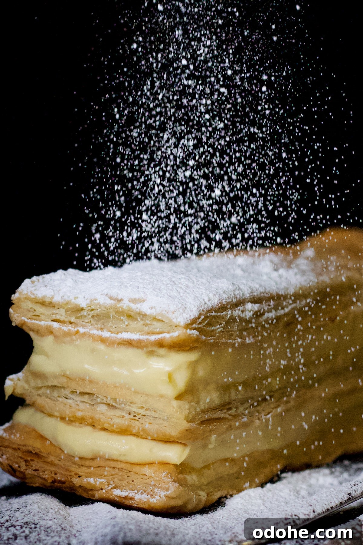 Mille-Feuille (Napoleon) Cream Pastry Recipe — Classic French Dessert 2 Sprinkling powdered sugar over the top of a classic French Napoleon right before serving.
