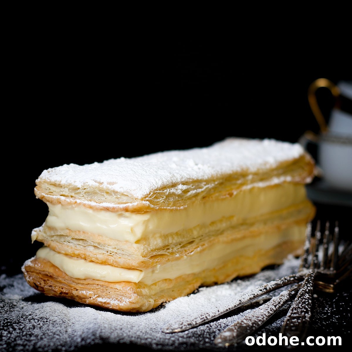 Mille-Feuille (Napoleon) Cream Pastry Recipe — Classic French Dessert 6 A classic Napoleon dessert sprinkled with powdered sugar on a plate and ready to serve.