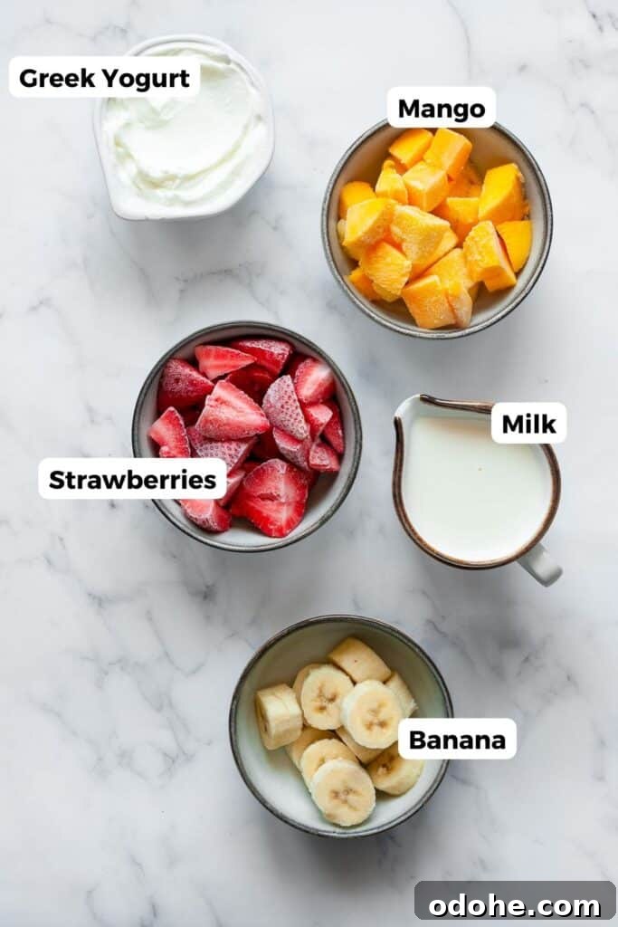 Creamy Banana, Mango & Strawberry Smoothie Recipe 4 all five ingredients in this banana mango strawberry smoothie in small bowls with labels