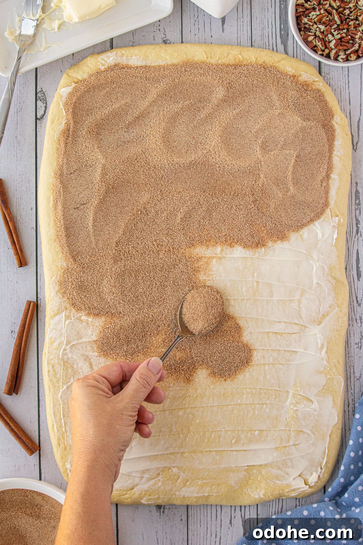 Giant Texas-Style Cinnamon Rolls: Soft, Gooey, Oversized Treat 8 Cinnamon sugar being added over the butter.