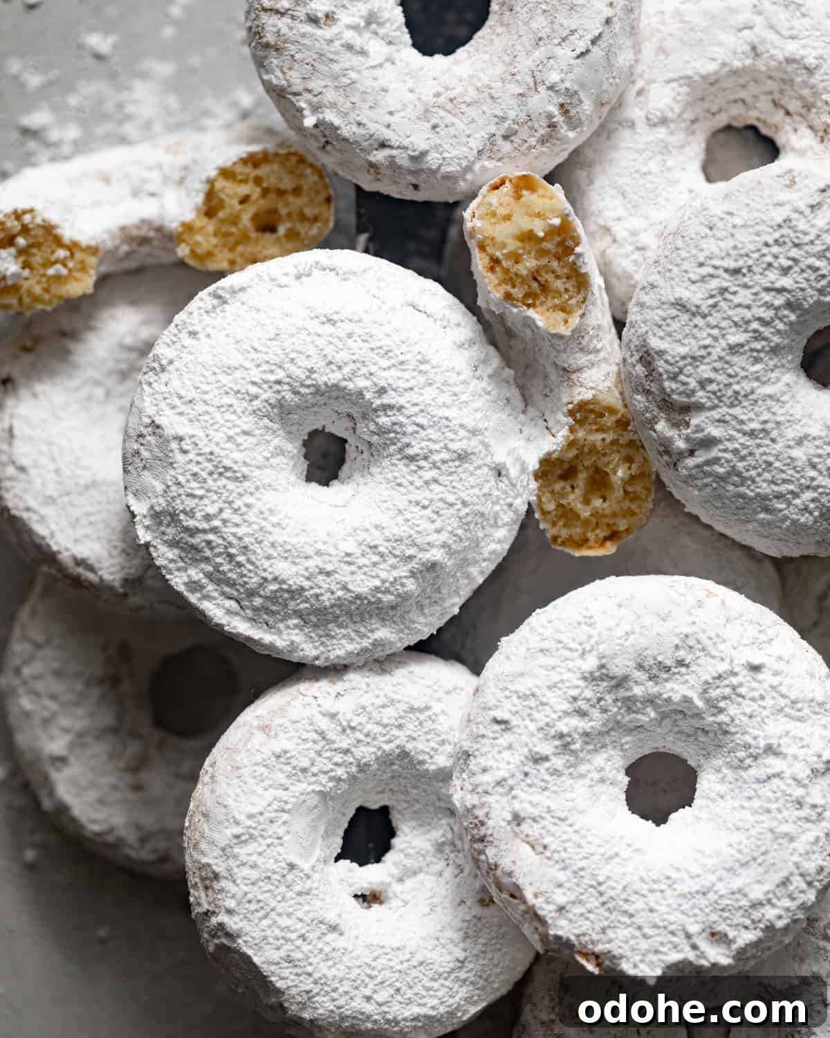 Powdered Sugar Donuts Recipe: Light, Fluffy Homemade Donuts 3 overhead photo of powdered sugar donuts laid flat on a white surface.