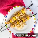 Two chicken kebabs resting on a bed of rice.