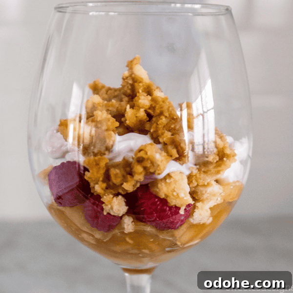 Enjoy a delightful Leftover Pie Parfait in a glass, featuring layers of luscious raspberries, fluffy whipped cream, and a crumbled topping that adds the perfect crunch.