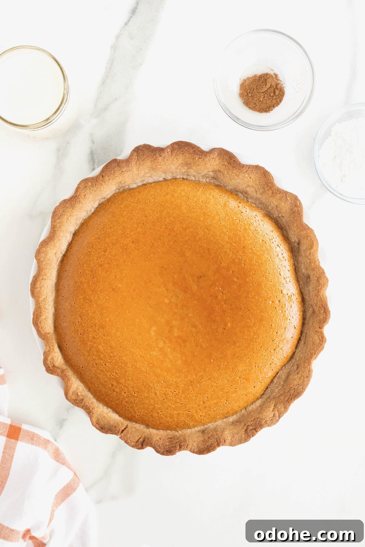 Creamy Pumpkin Pie Recipe: Classic Autumn Dessert Guide 11 A baked pumpkin cream pie on a white marble counter.
