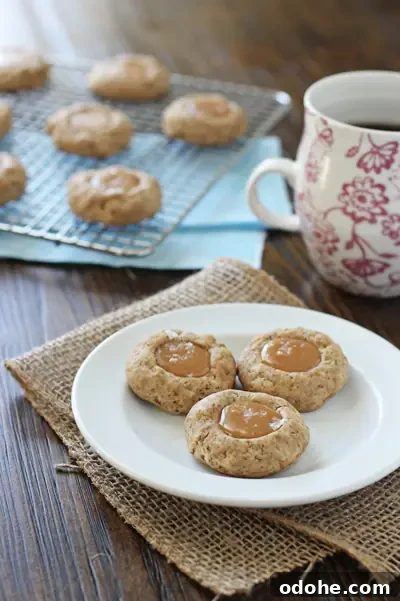Caramel Thumbprint Cookies on a plate with coffee to the side.