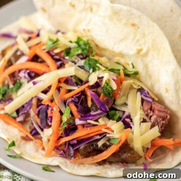 Tortillas with corned beef and slaw on plate.