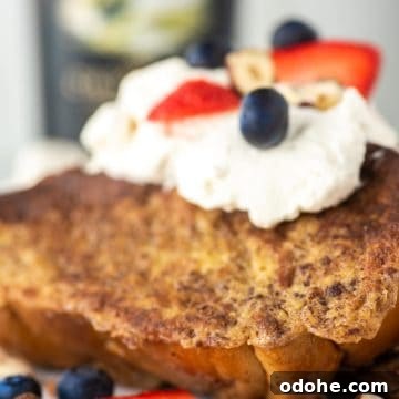 Baileys-Infused French Toast Recipe for Adults 13 French toast with Baileys whipped cream on white plate.