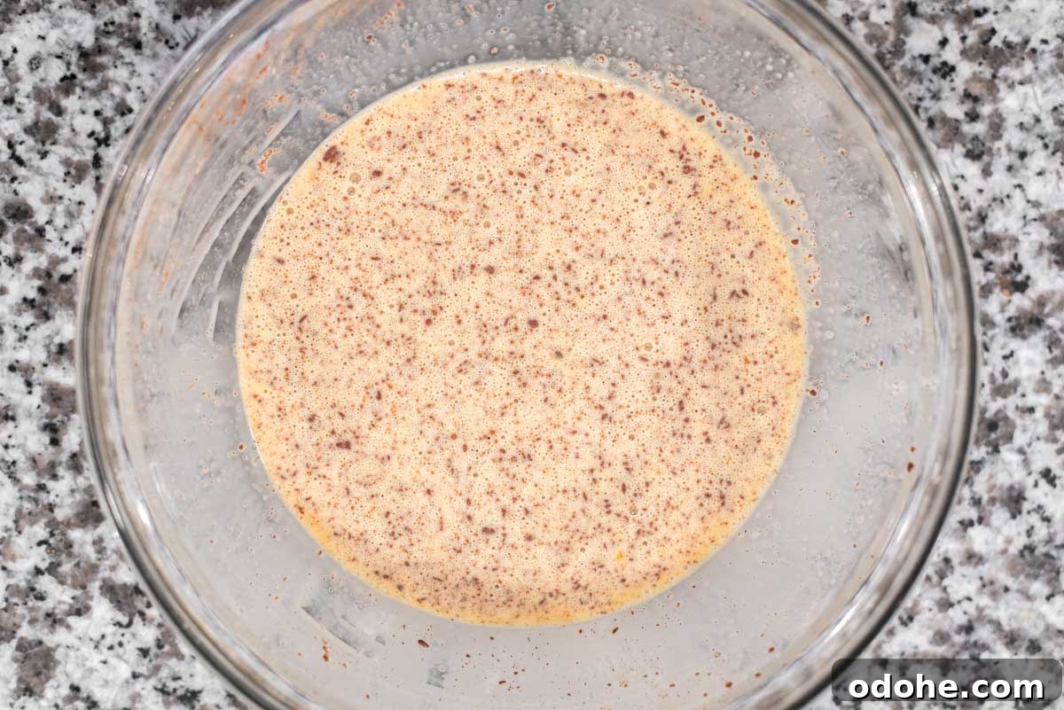 Baileys-Infused French Toast Recipe for Adults 4 Custard for French toast in glass bowl.