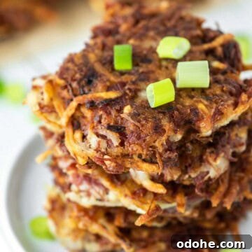 Corned beef fritters stacked on white plate.