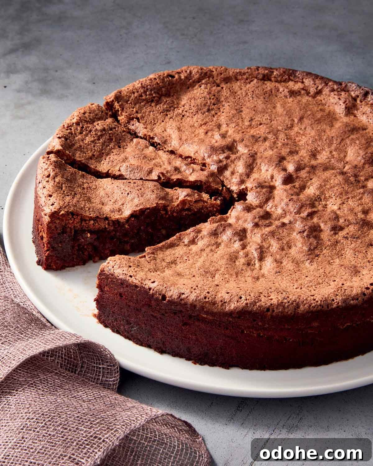 Dorie Greenspan's mocha walnut torte on a white plate with two pieces sliced and one piece missing.