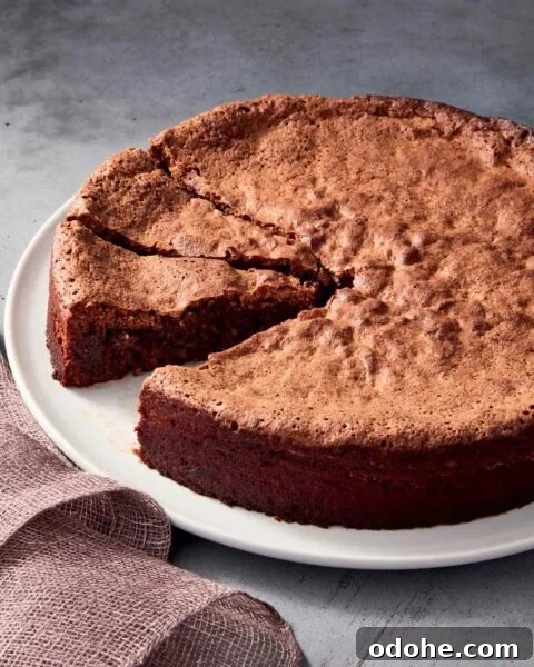 Mocha walnut torte on a white plate with 2 pieces sliced and 1 piece missing.