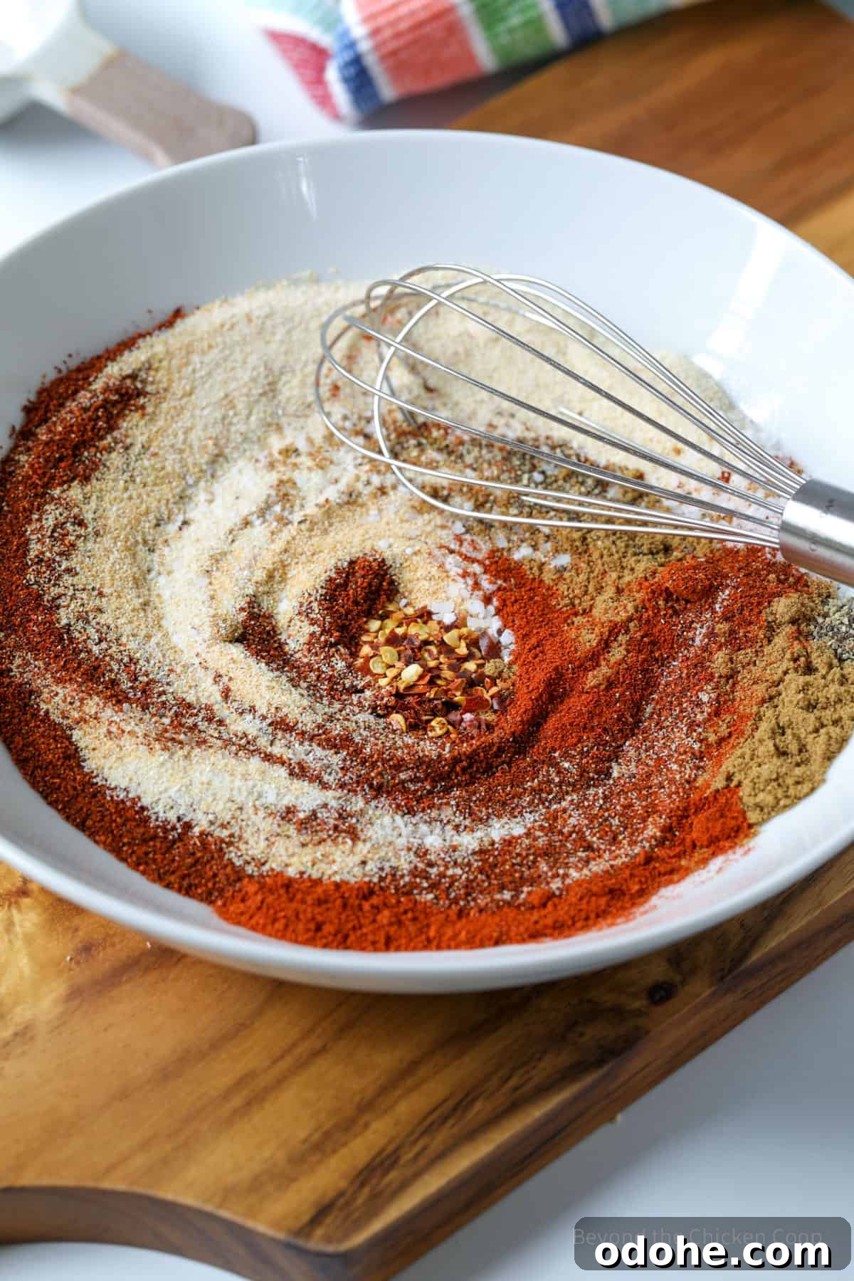 Spices in a bowl with a whisk.