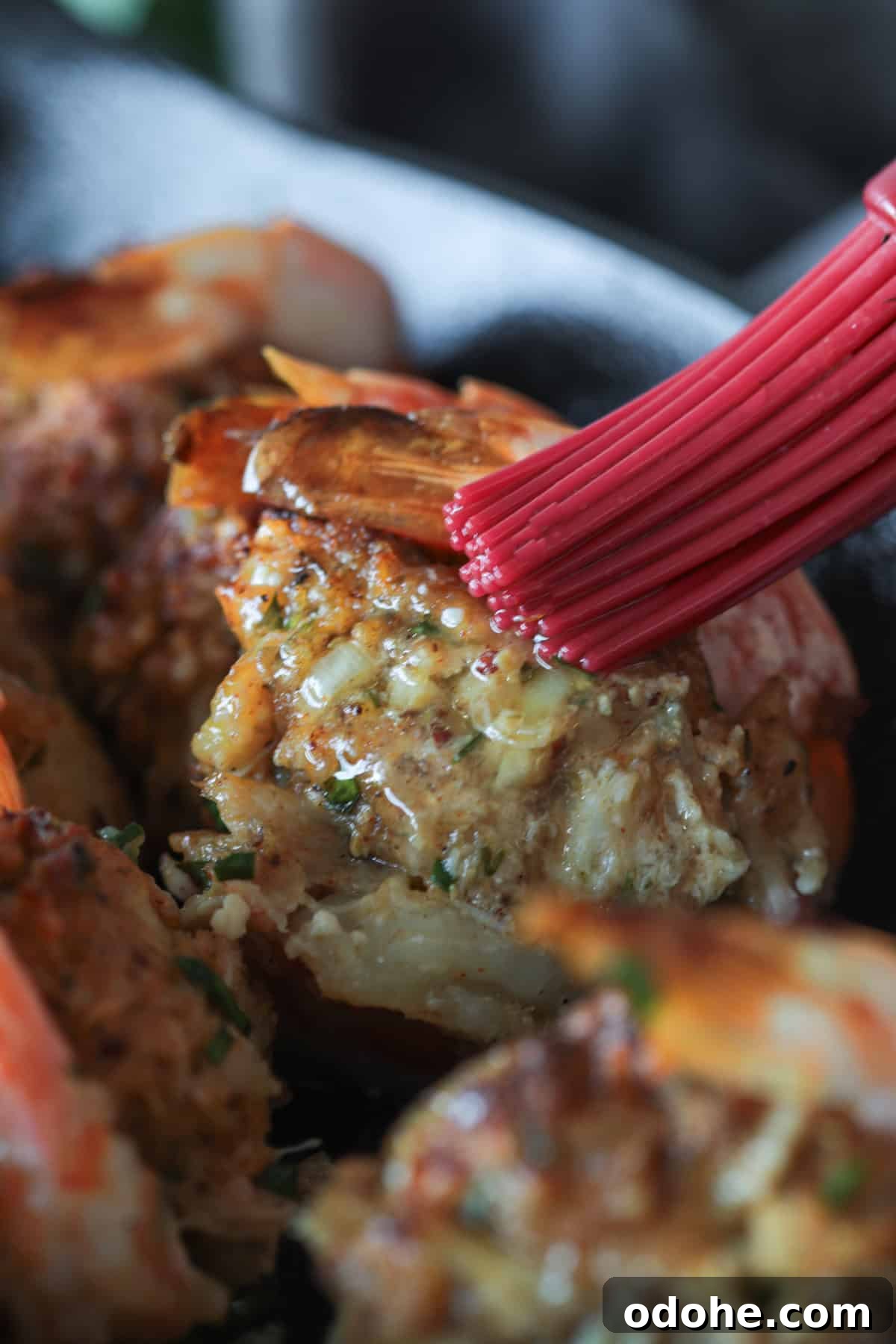 Brushing stuffed shrimp with melted butter.