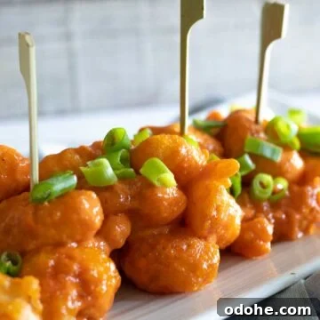 Dynamite shrimp appetizer on plate with skewers.