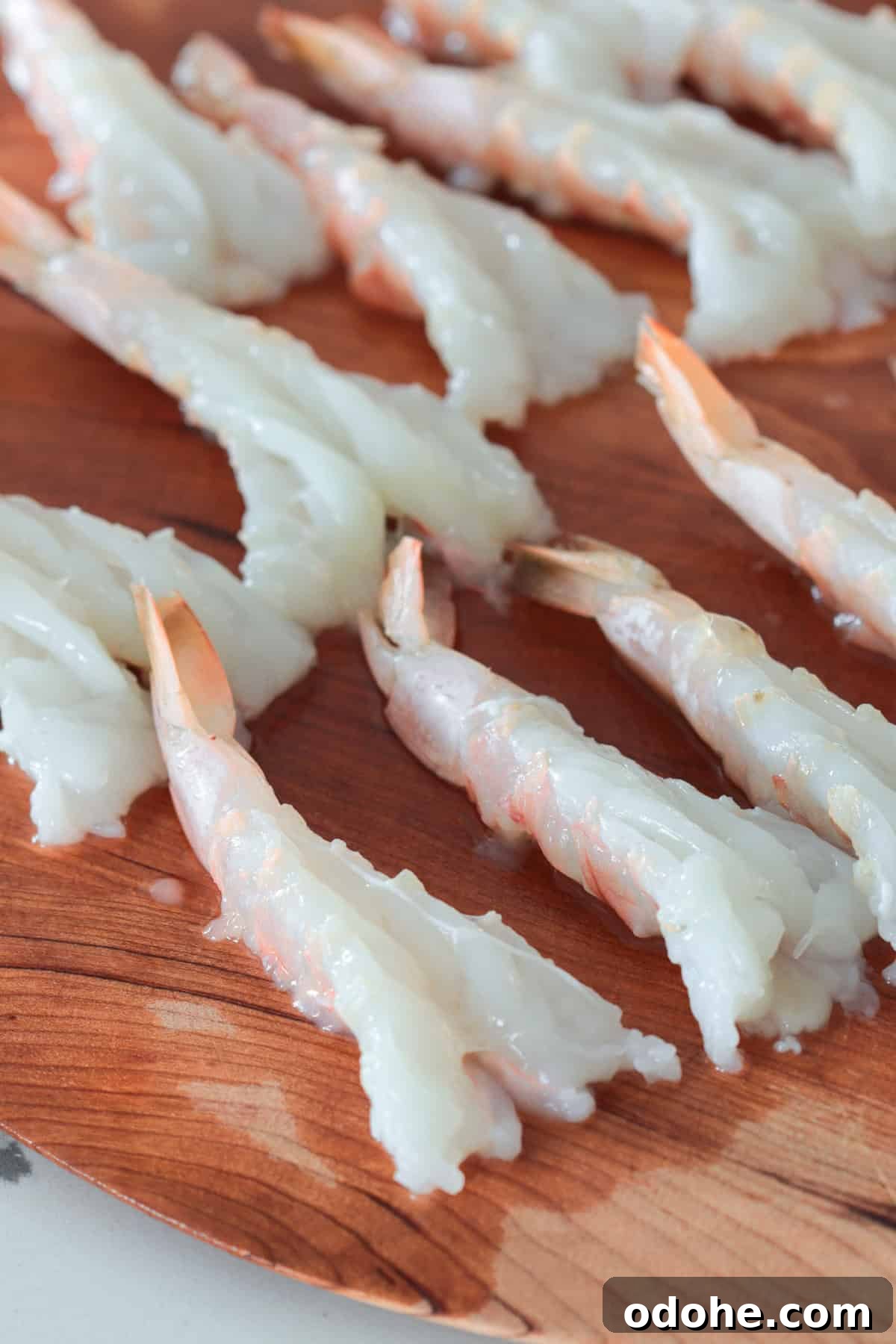 Butterflied shrimp on cutting board.