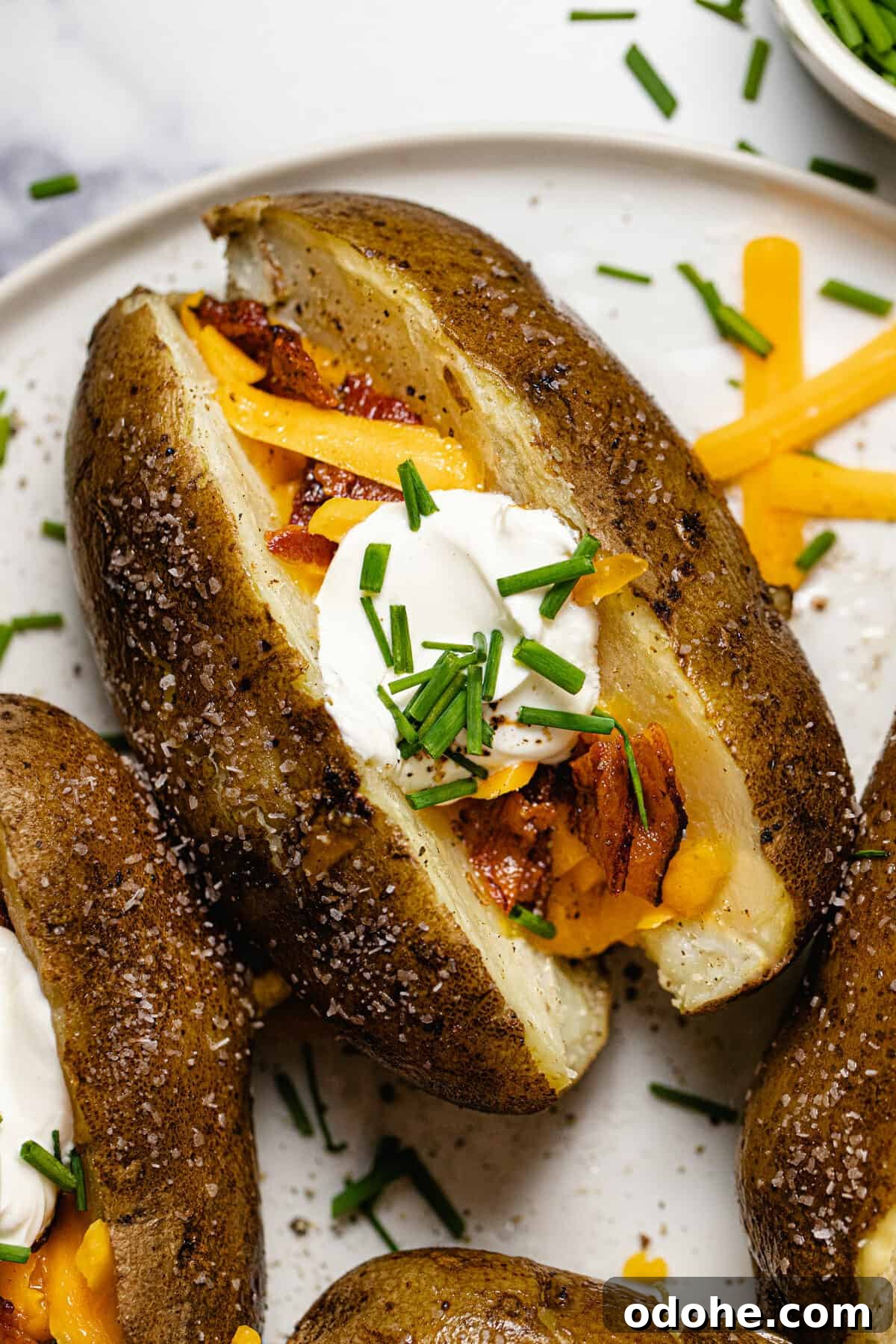 Close up overhead shot of a loaded baked potato on a white plate