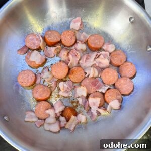 Sausage and bacon cooking in a pan.