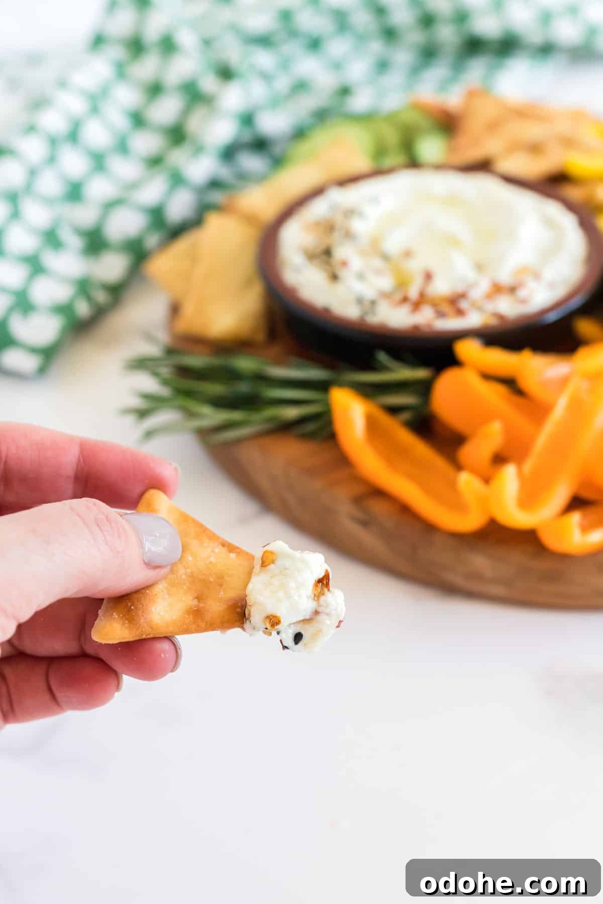 Creamy Whipped Feta Dip Recipe for Parties and Appetizers 9 hand holding chip with feta dip on it